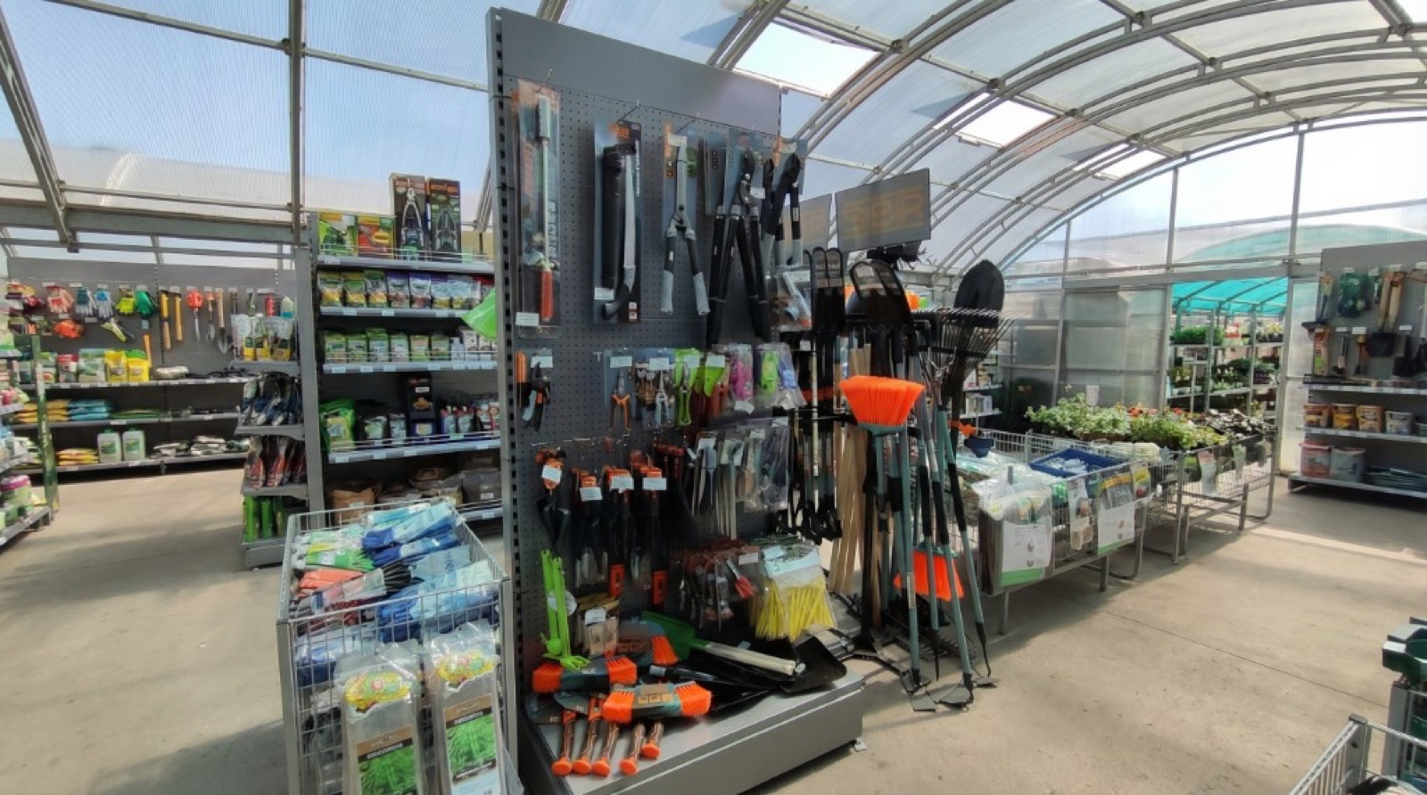 Садовый инвентарь и ручной инструмент на стенде в садовом центре